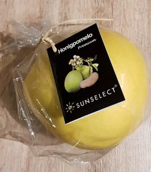 Unnötige Plastikverpackung für eine Honigpomelo