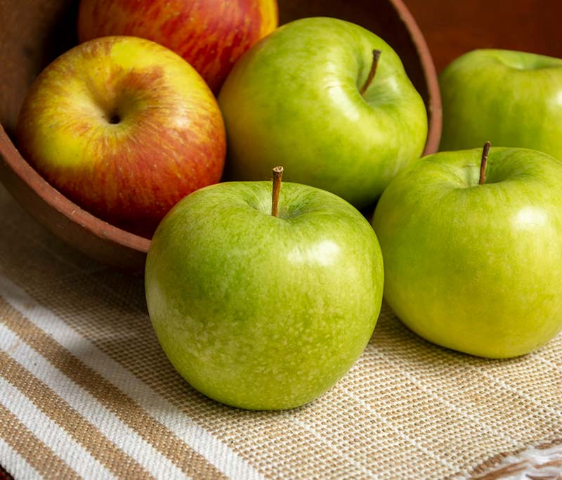 Green and red apples in skin