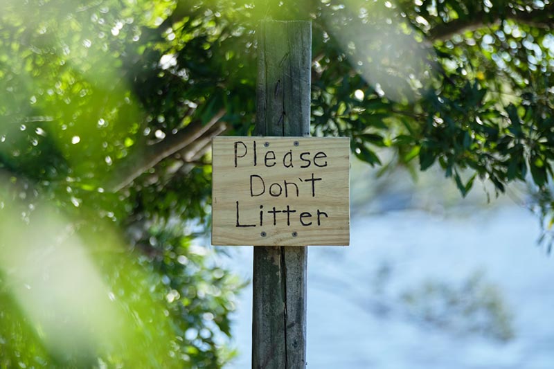 Schild mit der Aufschrift "Please don't litter"