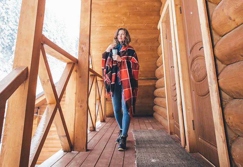 Woman in front of modern wooden house