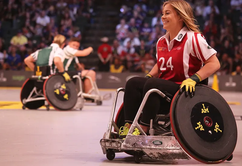 Glückliche Rollstuhlfahrerin beim Sport