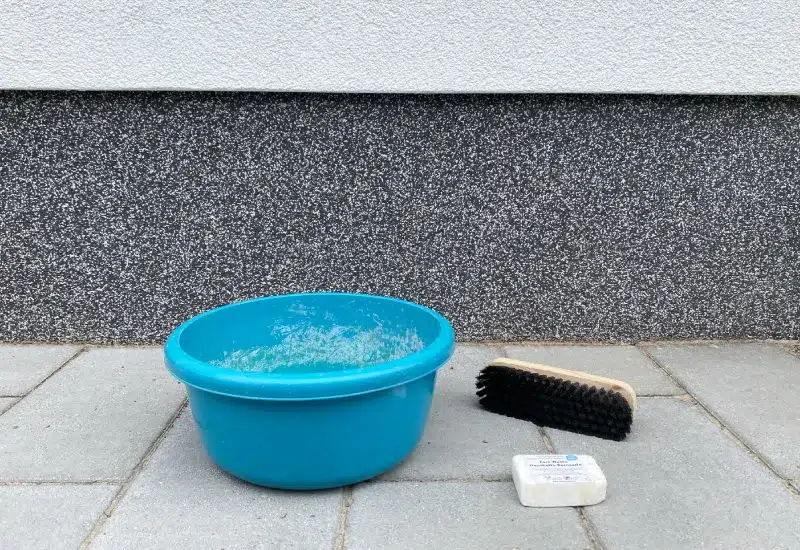 Hausfassade mit Wasser, Bürste und Kernseife säubern
