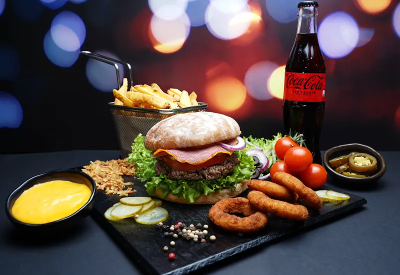Burger mit Pommes und Käsesauce und Cola serviert