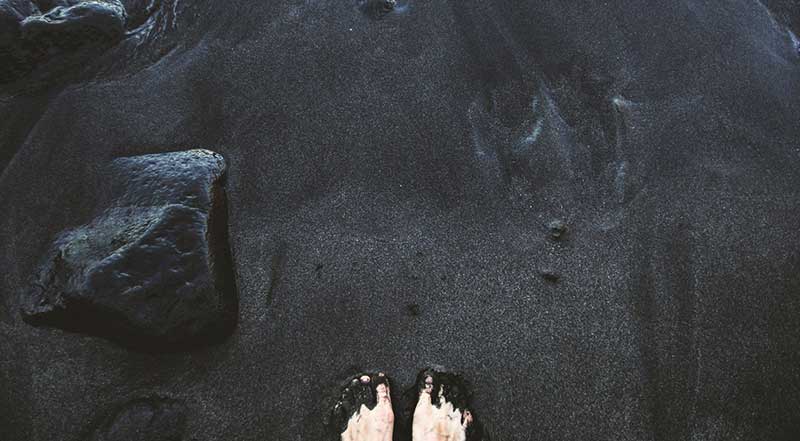 Feet in the beach sand - To be satisfied and to know