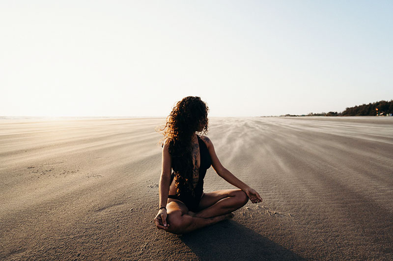 Woman meditating on beach